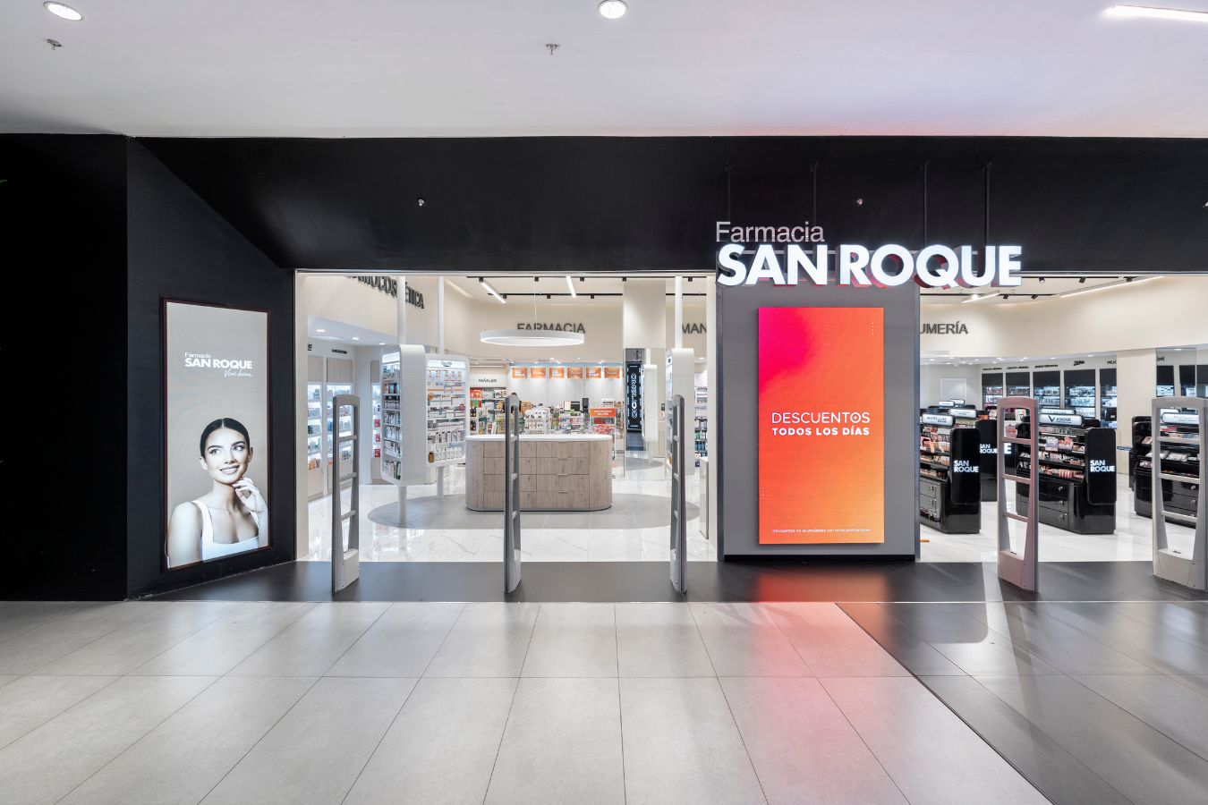 San Roque Pharmacy - Interior view of main entrance with security gates and promotional digital screens - Contract Workplaces.jpg